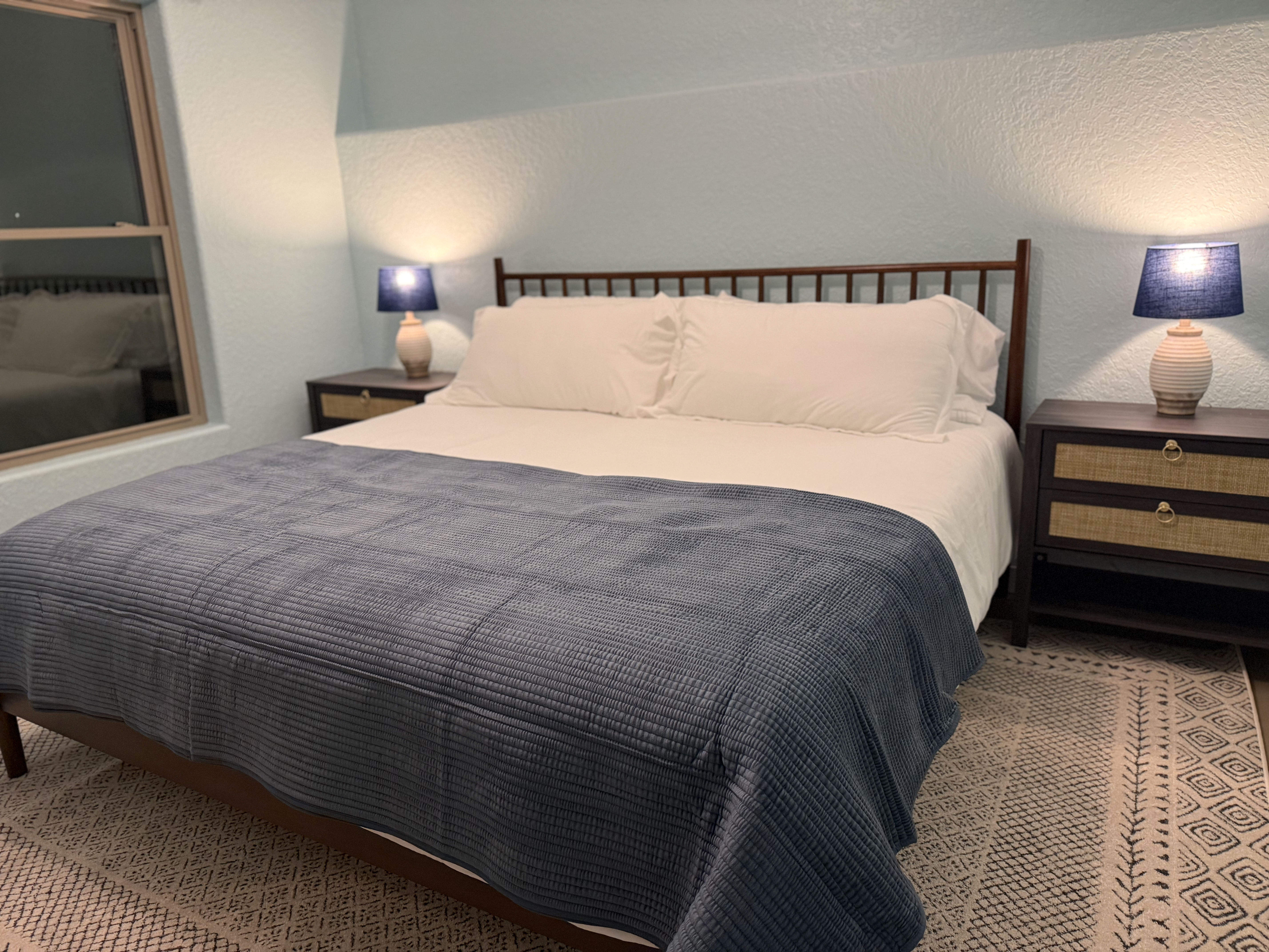 King bedroom with blue bedding and navy lamps