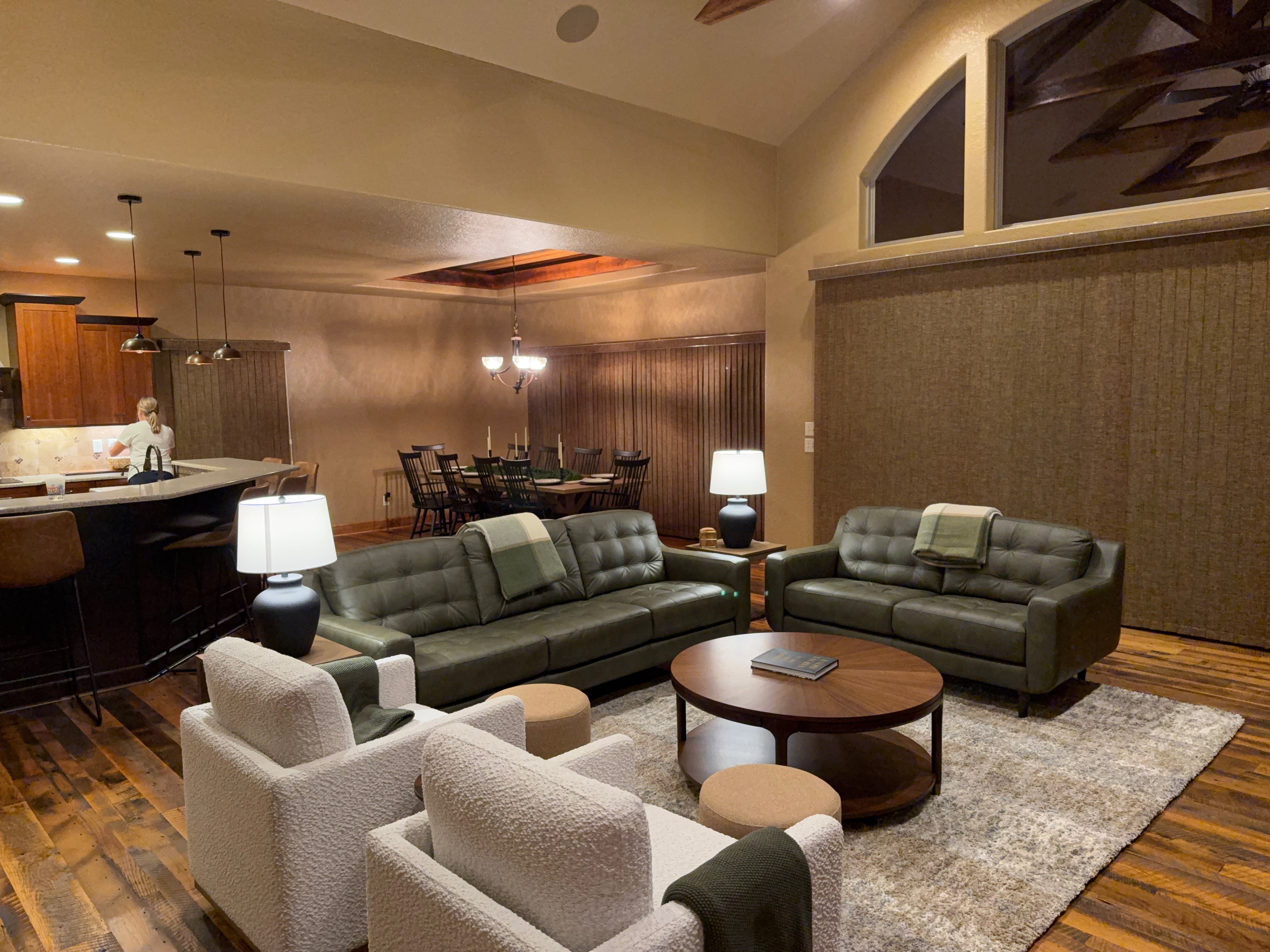 Main level living room with green leather sofas and barnwood floors