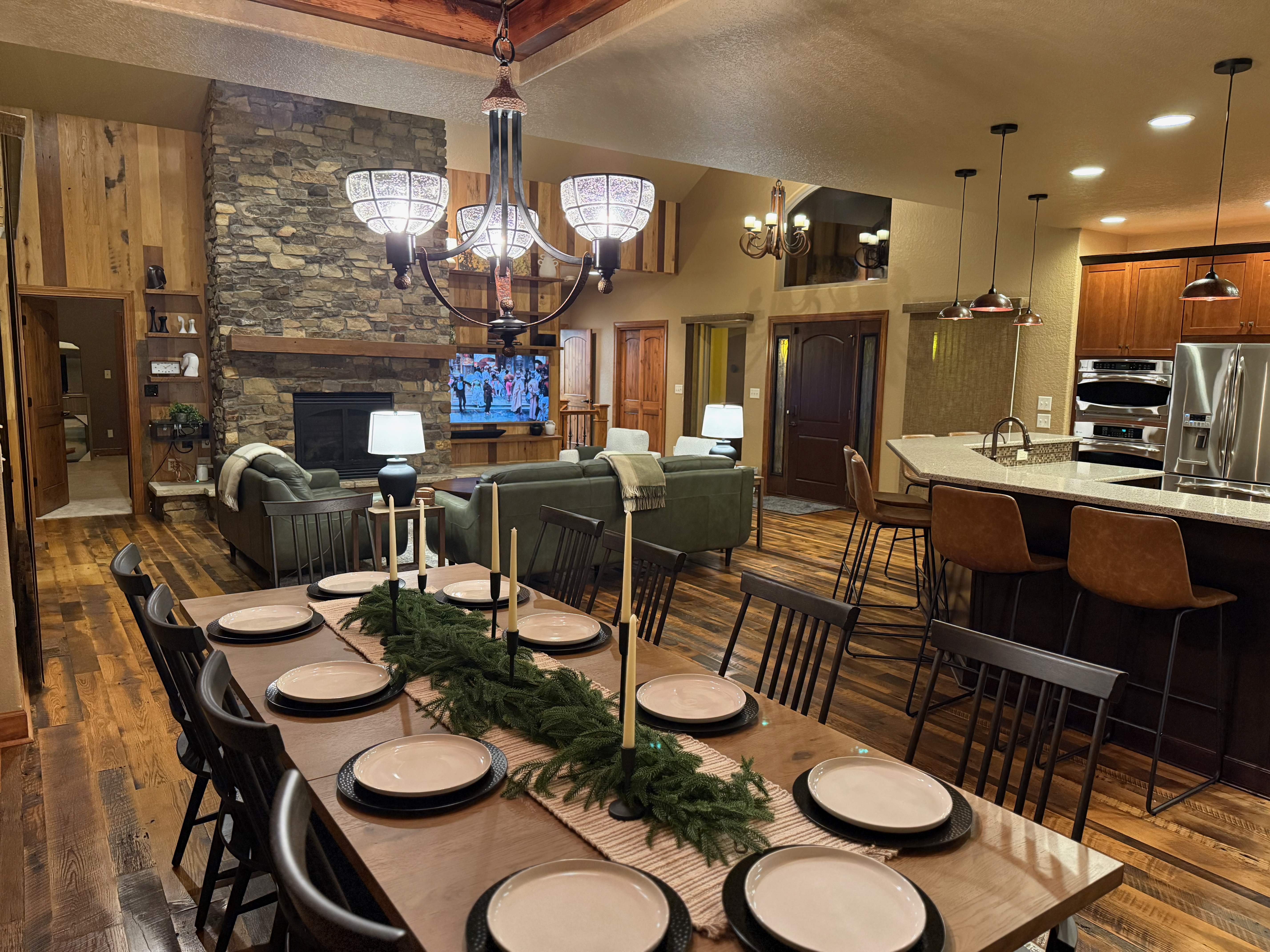 Open-concept dining, living room and kitchen with stone fireplace