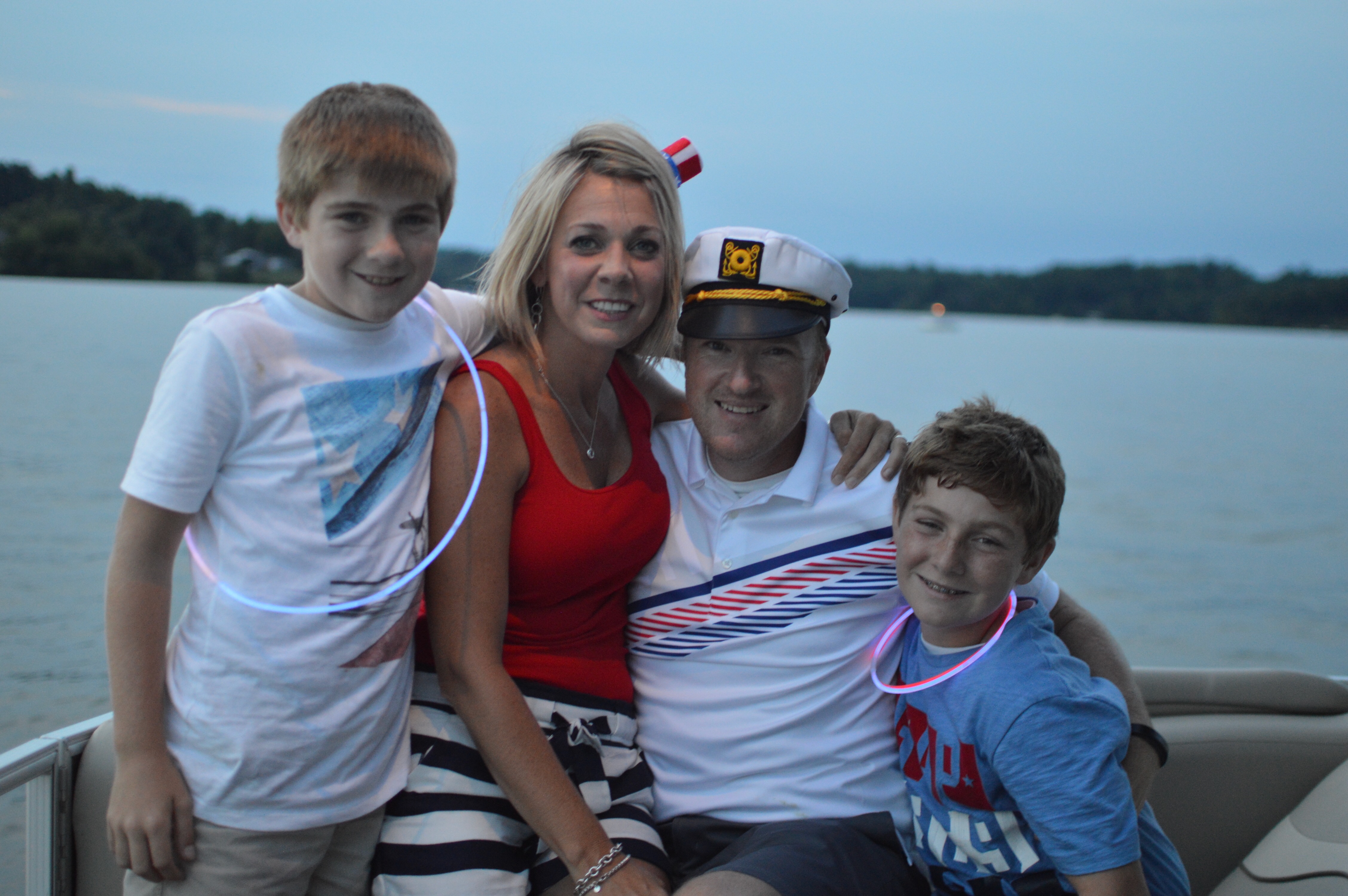 The Gray family on a boat at sunset on the lake