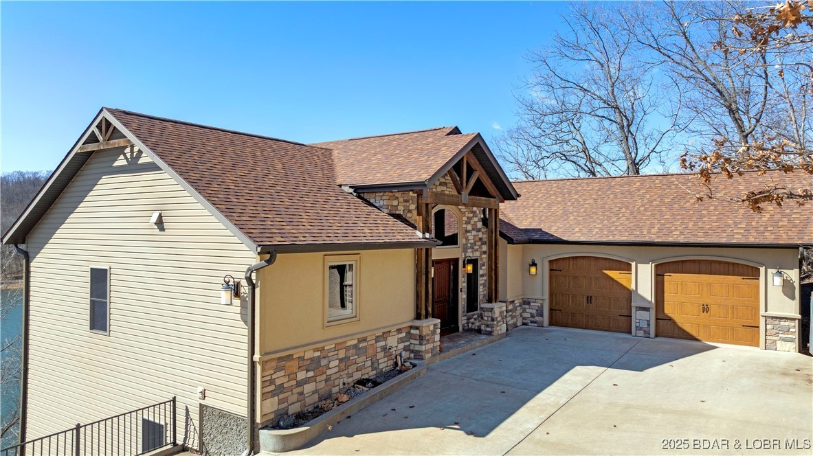 Front exterior with stone accents and wooden garage doors